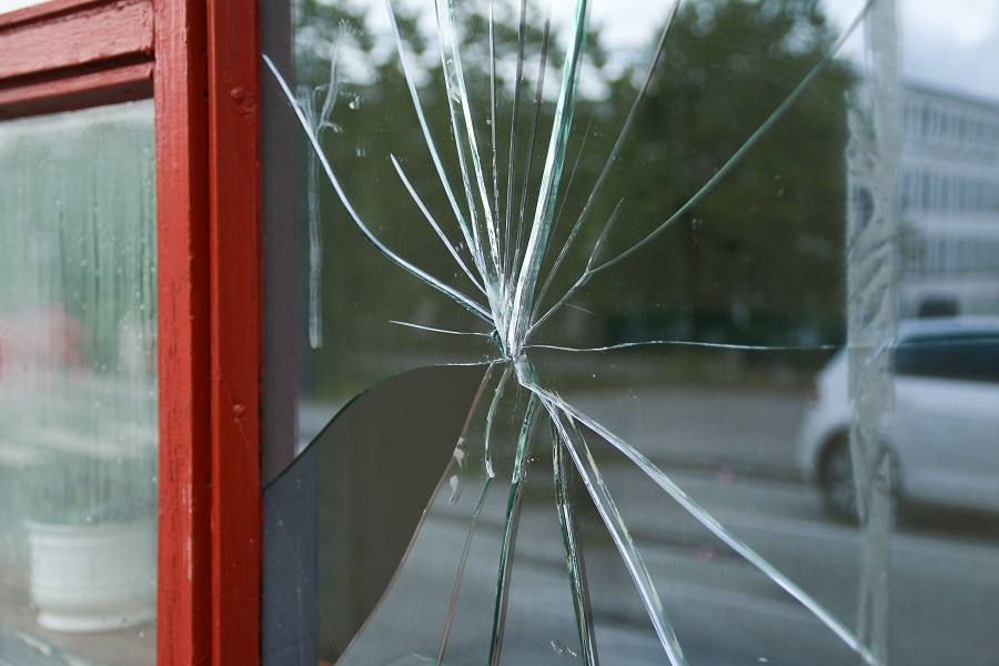 Krossad fönsterruta med röd fönsterkarm.