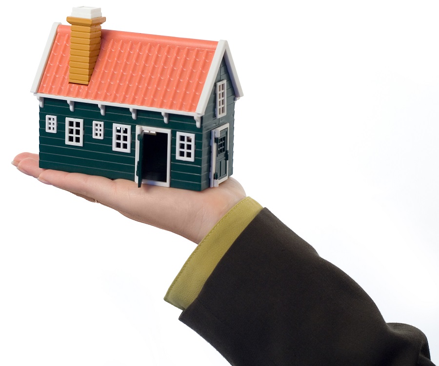 En hand som håller en modell av ett hus
