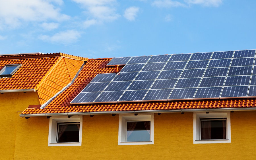 Solceller på tak på ett gulmålat hus