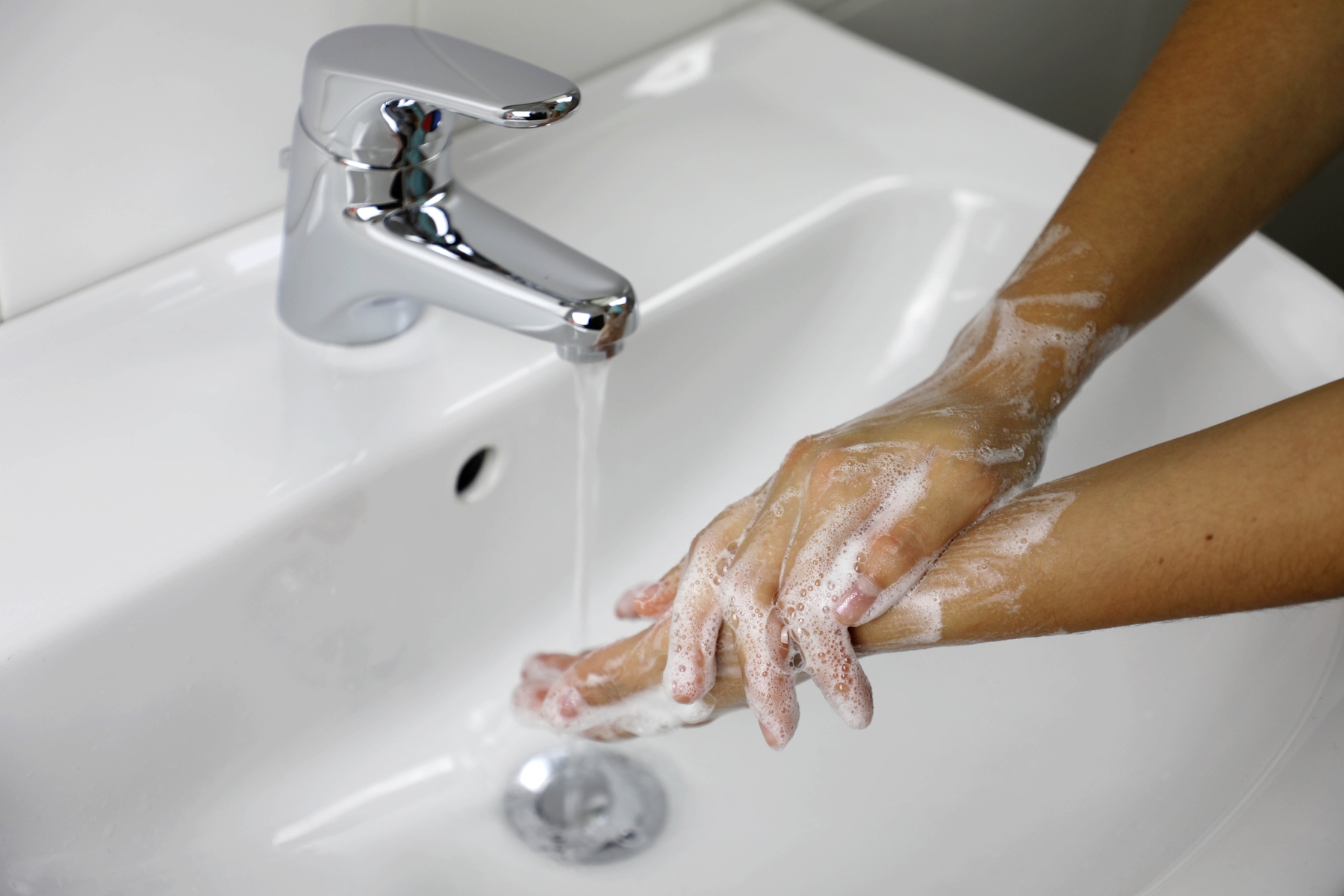 Handtvätt under rinnande vatten i handfat
