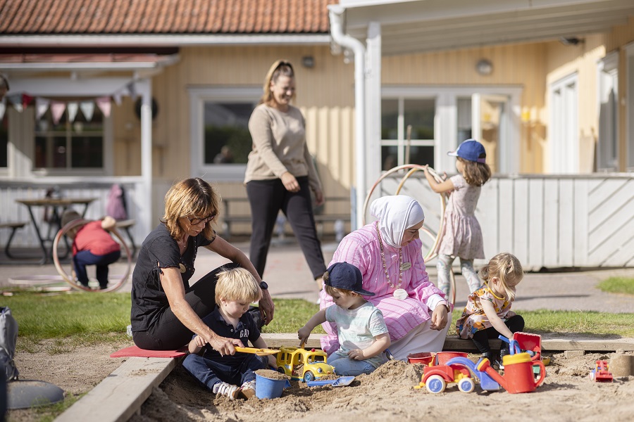 Barn och personal leker i sandlådan på förskolan Sundsängen.