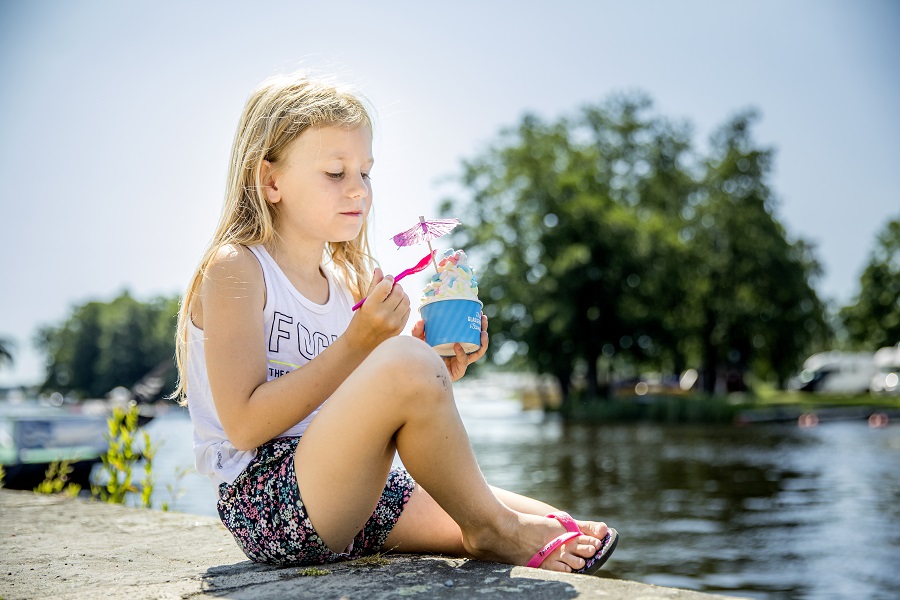 Flicka äter glass i Askersunds hamn.