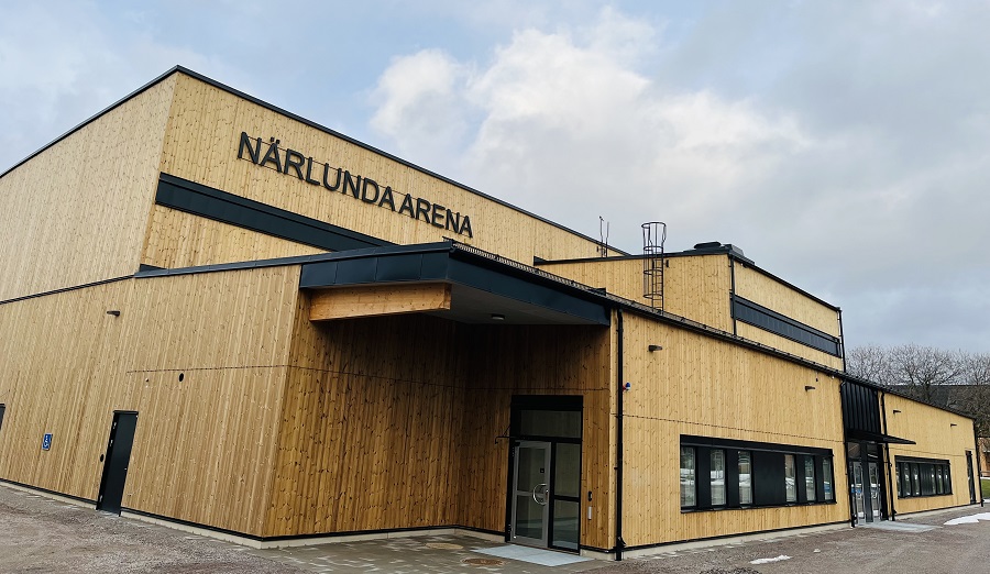 Närlunda Arena fotograferad från utsidan, en stor byggnad med träfasad.