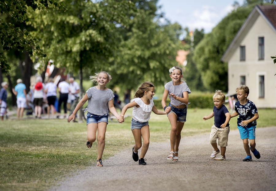 Några barn och ungdomar springer längs Strandpromenaden i Askersund.