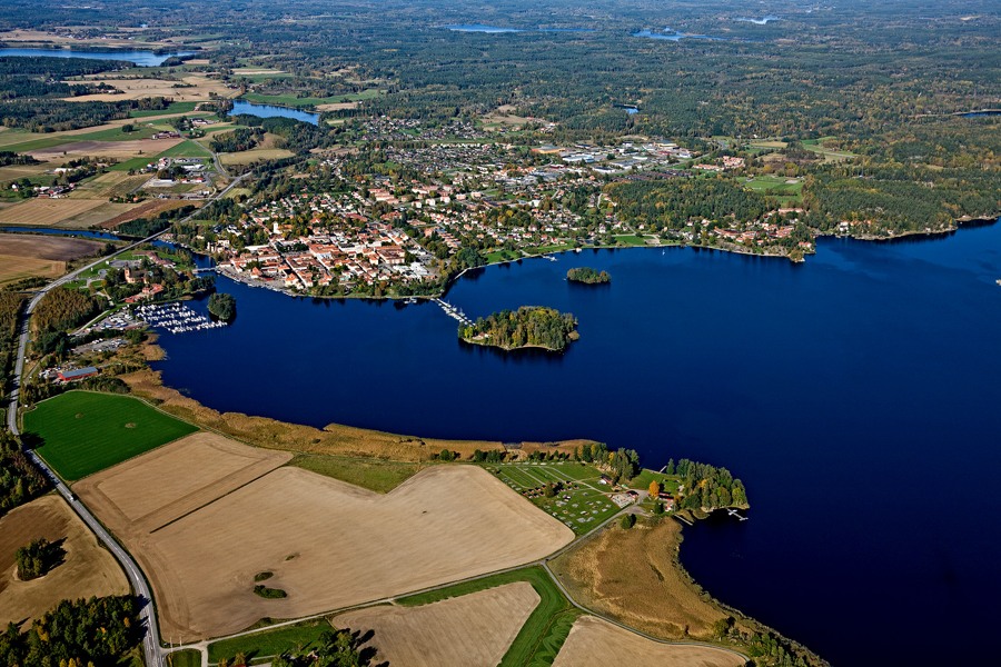 Flygbild över Askersund med omgivningar. Jordbruksmark och Alsen i förgrunden, omgivna av staden och landsbygd 