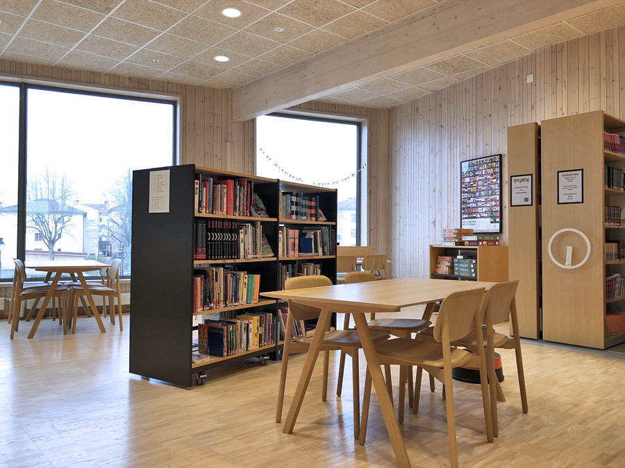 Bokhyllor, bord och stolar i ett bibliotek