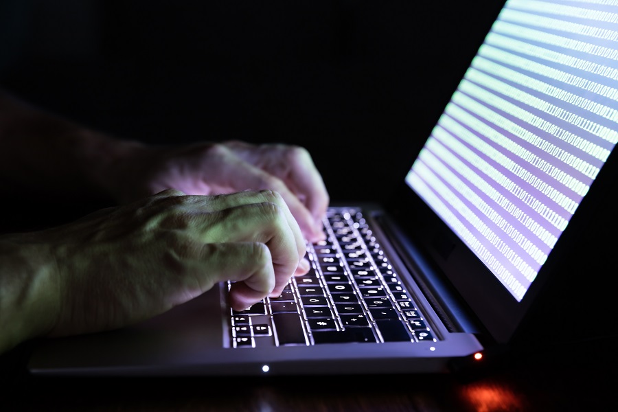 Händer på en person som skriver på ett tangentbord på en bärbar dator.